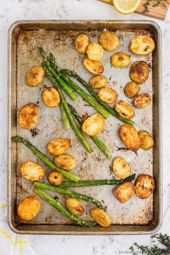 The potatoes and asparagus on a sheet pan.