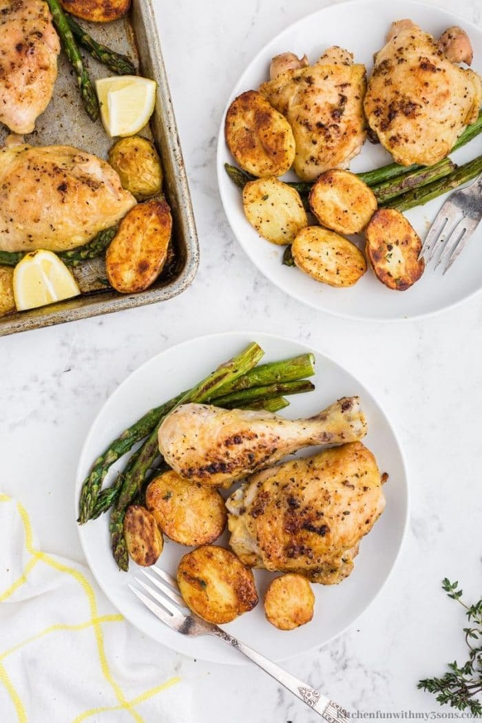 Baked chicken, potatoes and asparagus on a plate with a fork