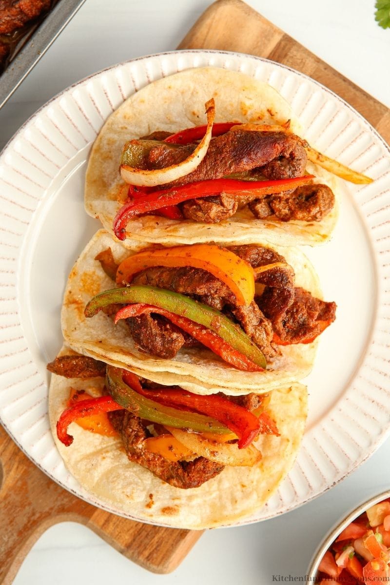 The steak fajitas with some salsa on the side.