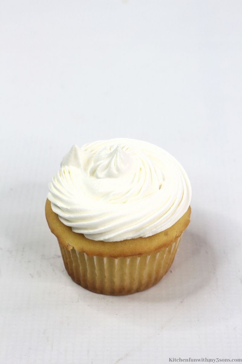 The cupcake topped with whipped cream.
