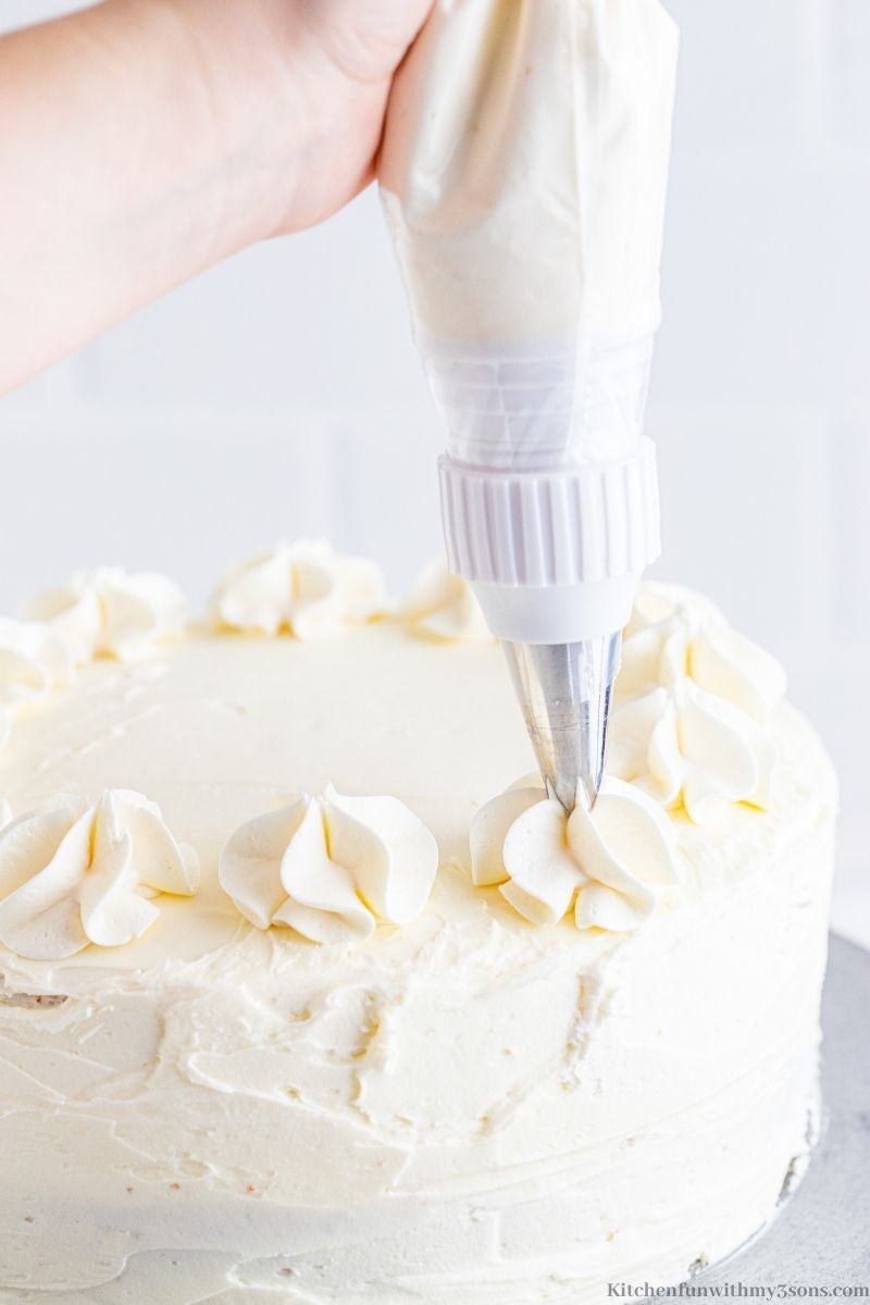 Piping frosting on top of a lemon cake