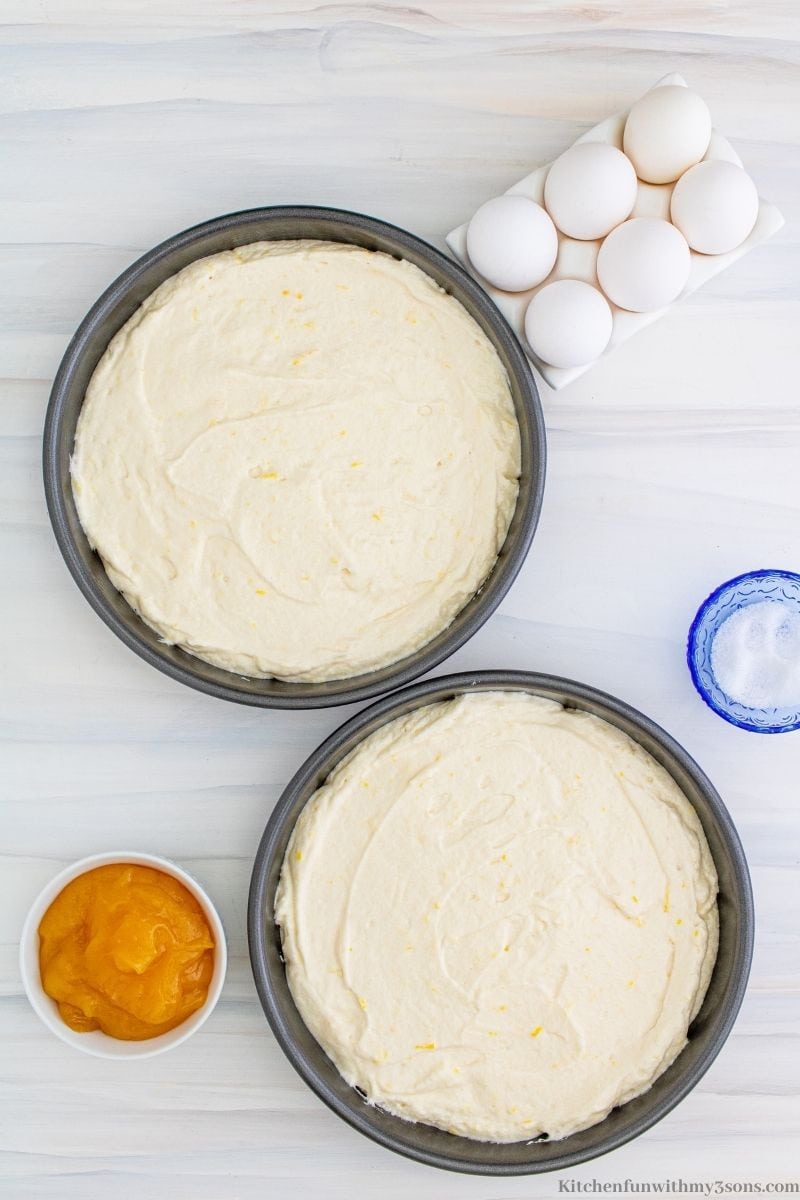 Overhead view of two round pans filled with lemon cake batter