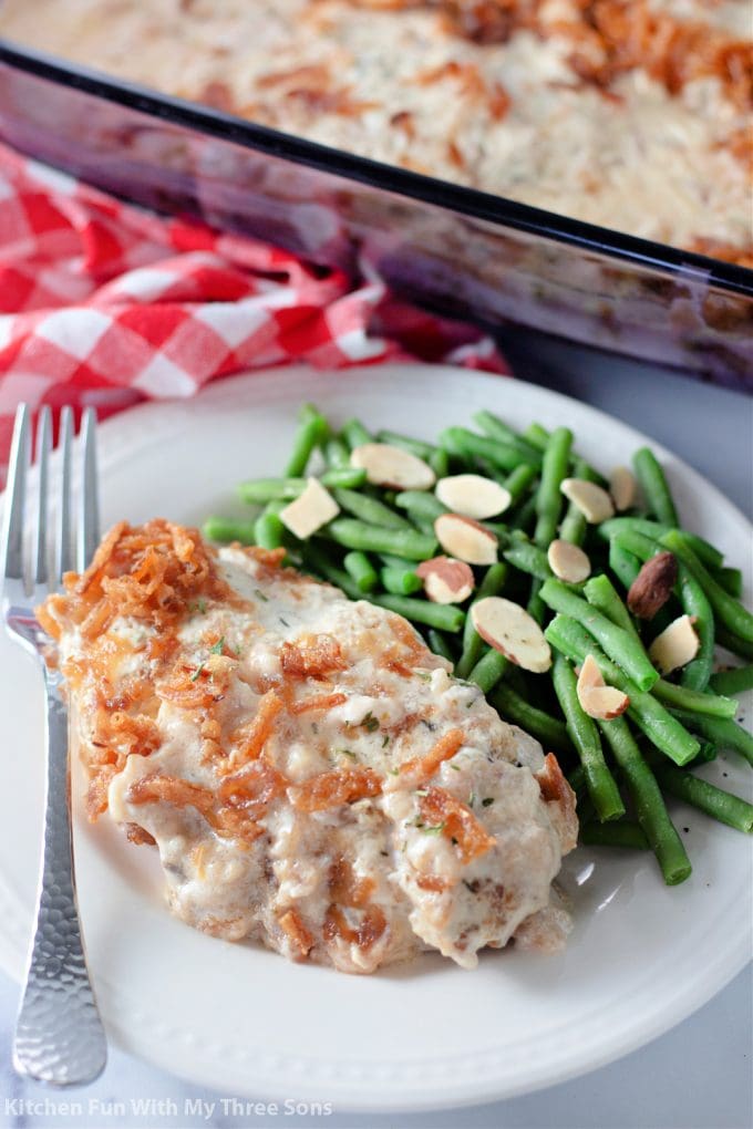 Pork Chop Casserole on a plate with green beans and almonds.