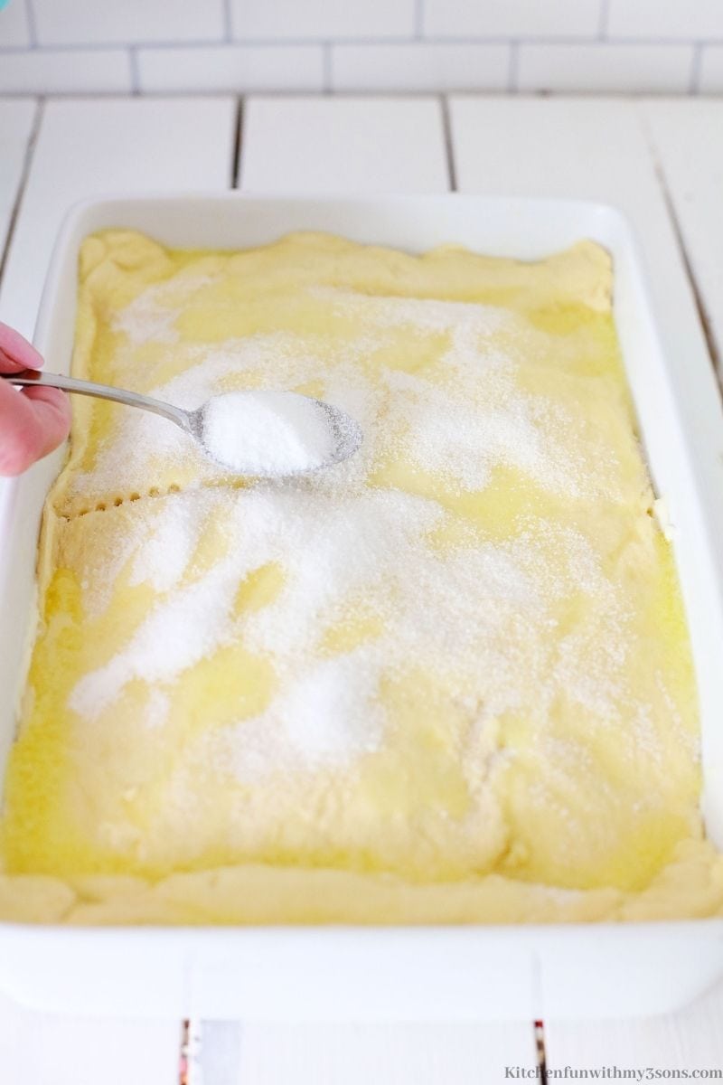 Adding sugar on top of the dough.