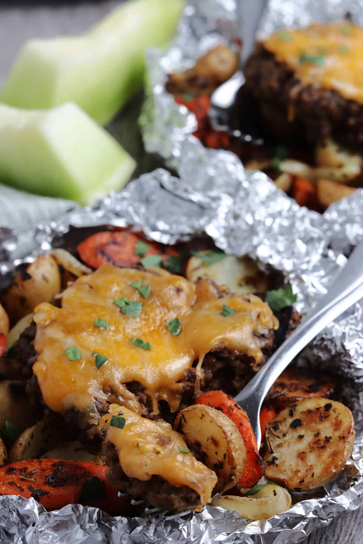With ground beef patties, potatoes, and veggies, Hobo Dinner Foil Packets are a quick, easy, and mess-free dinner for any night of the week. A fork in a hobo dinner foil packet