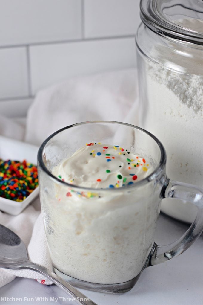 3-2-1 Microwave Mug Cake in a clear mug with frosting and sprinkles.