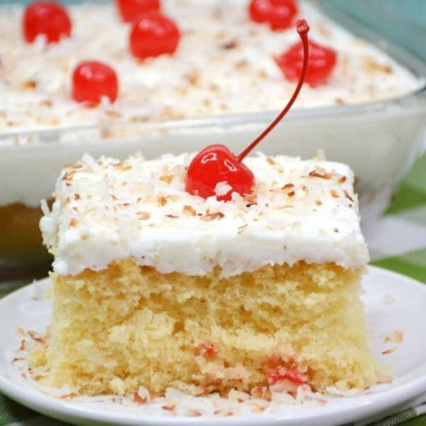 A piece of cake topped with a cherry.