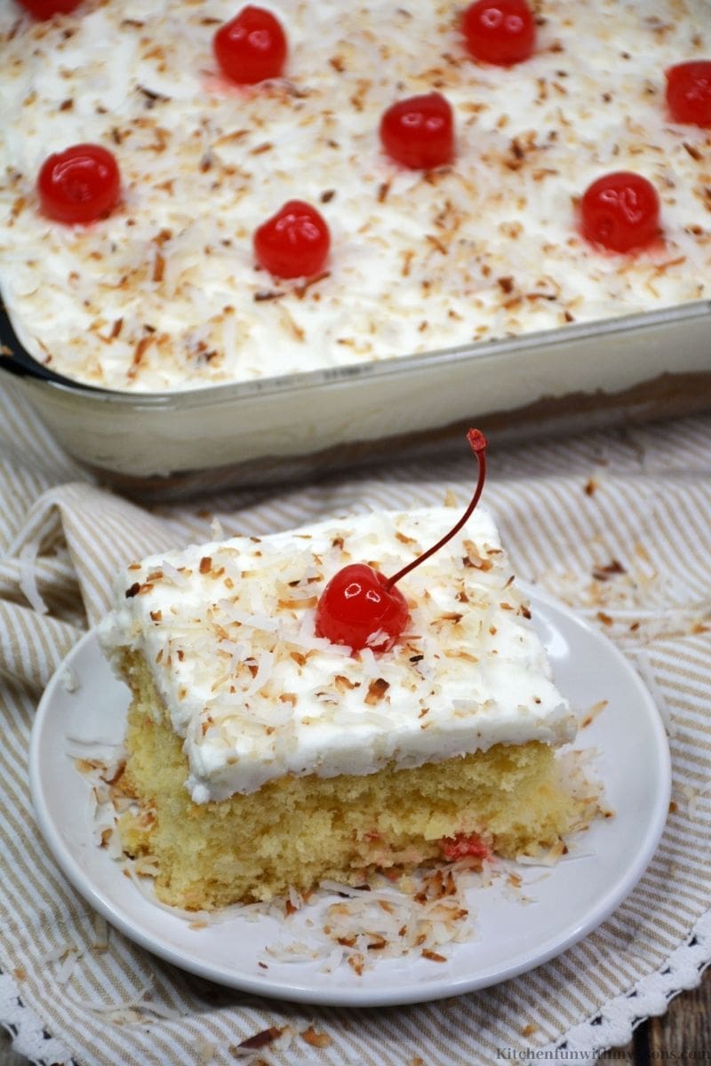 A piece of cake topped with toasted coconut.