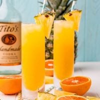 The cocktails with pieces of pineapple on the rims.