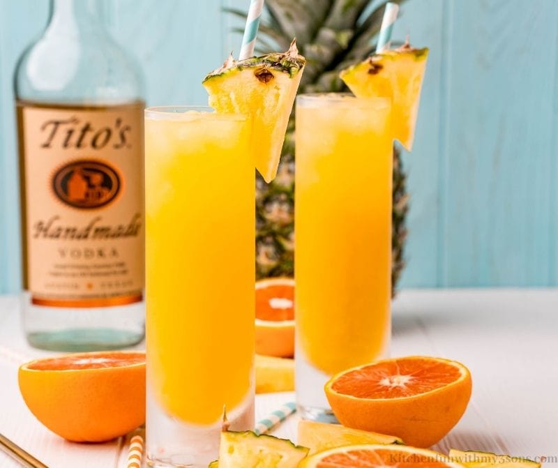 The cocktails with pieces of pineapple on the rims.