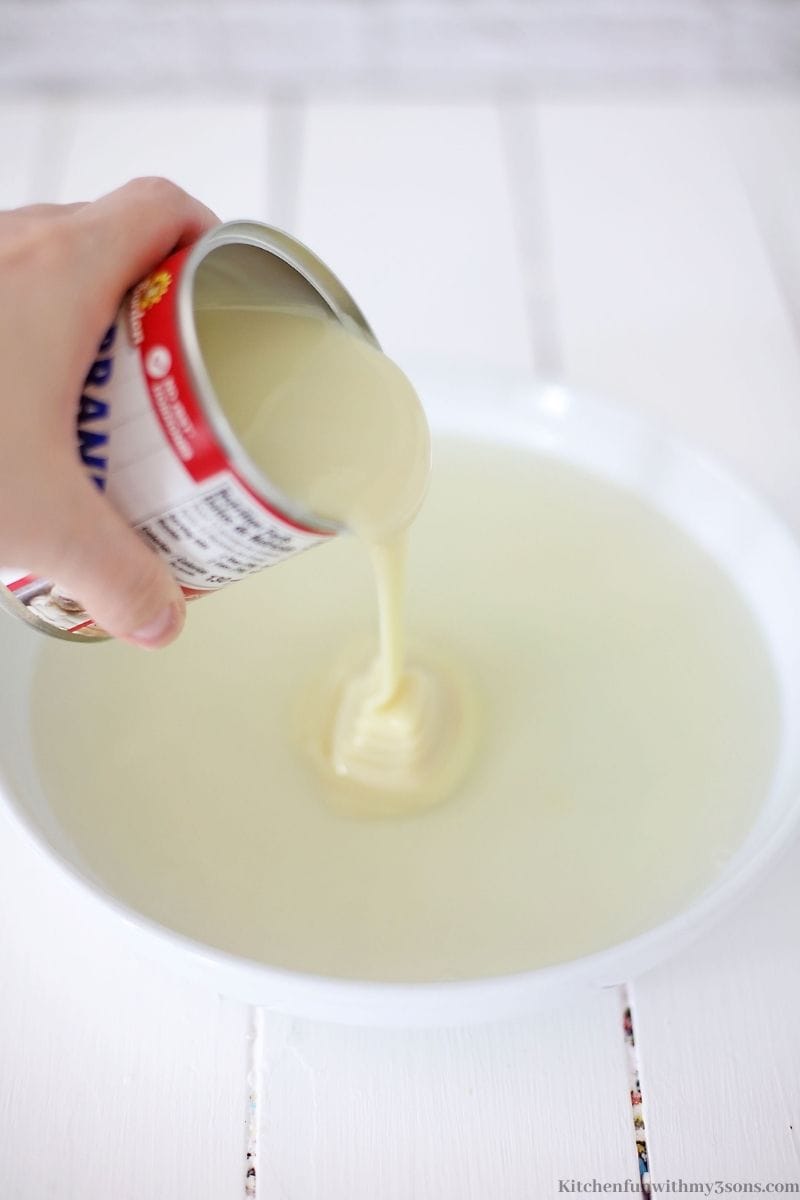 Adding the condensed milk into the bowl.