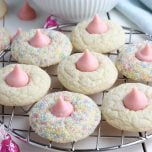 Strawberry kiss cookies on a round wire rack.