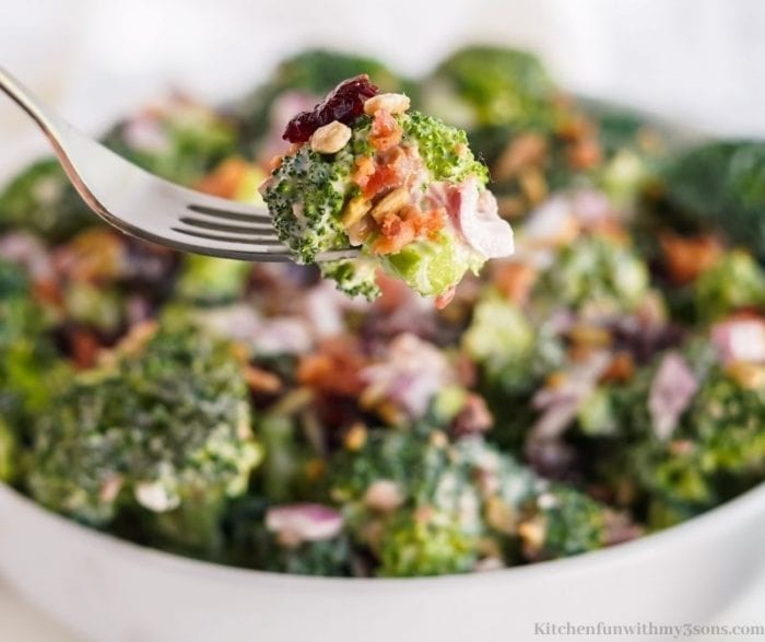 A fork lifting up some of the broccoli salad.