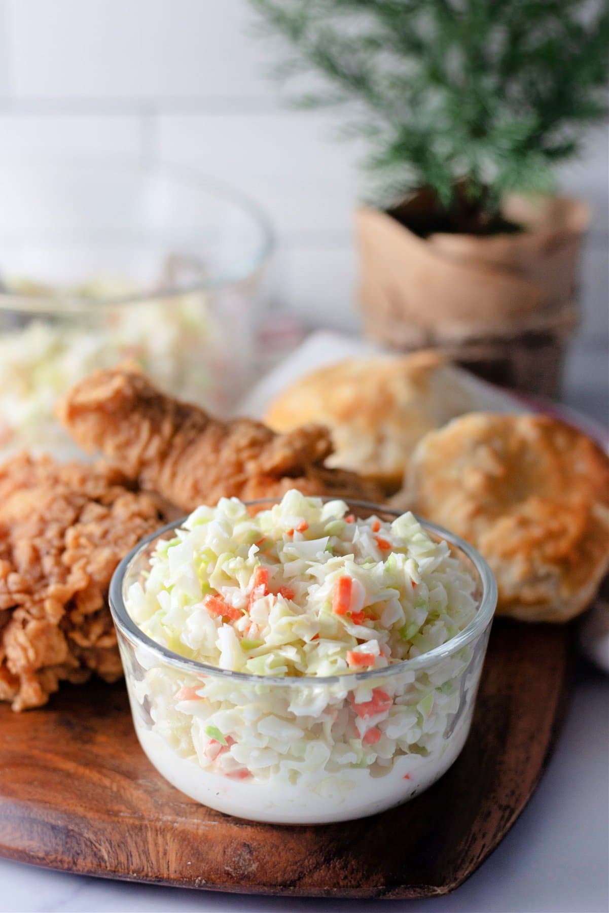KFC Coleslaw in a dish in front of fried chicken and biscuits