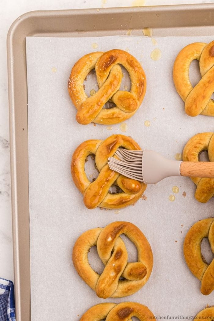 Brushing the pretzels with butter.