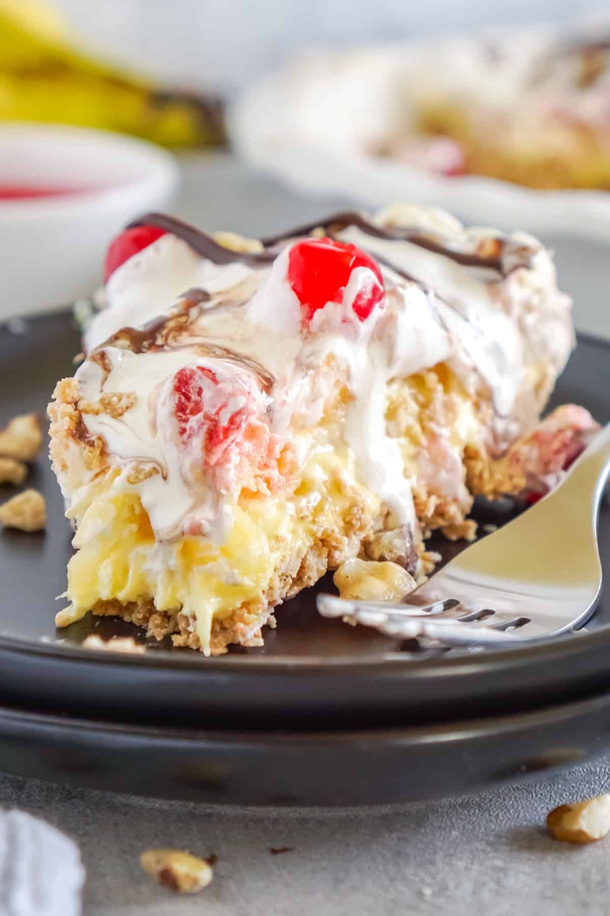 With layers of pudding, bananas, pineapple, cherries, and more, No Bake Banana Split Pie recipe features all the flavors of a banana split. Banana Split Pie slice on a plate