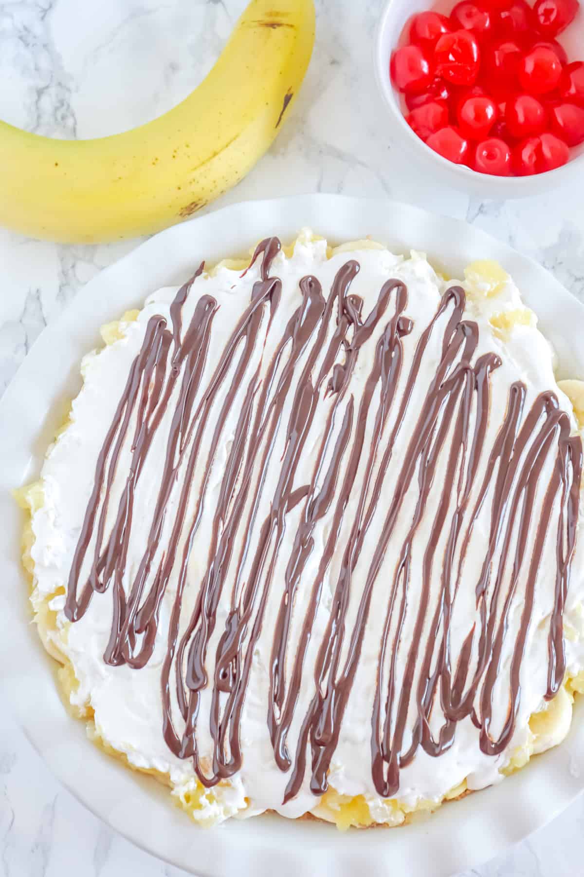 drizzling chocolate over the banana split pie