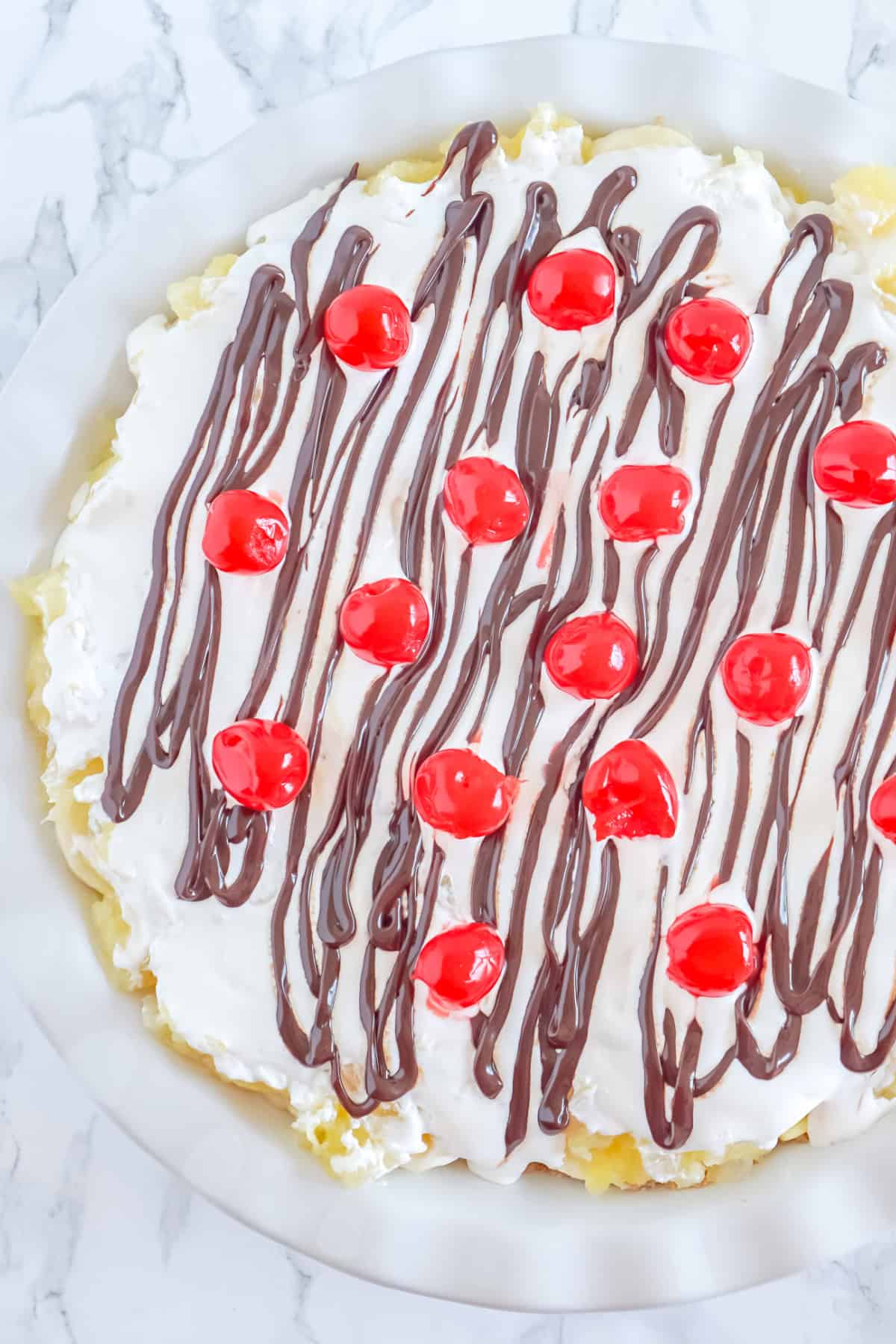 adding maraschino cherries to a banana split pie