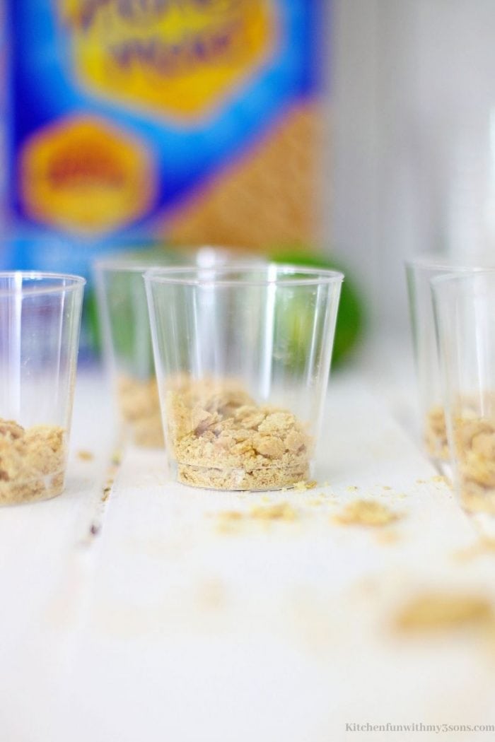 Adding the crumbs into the base of the shot glasses.