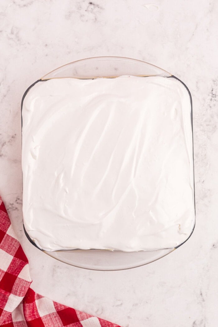 whipped cream on top of cake in a baking dish