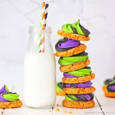 the cookies stacked by a glass of milk.