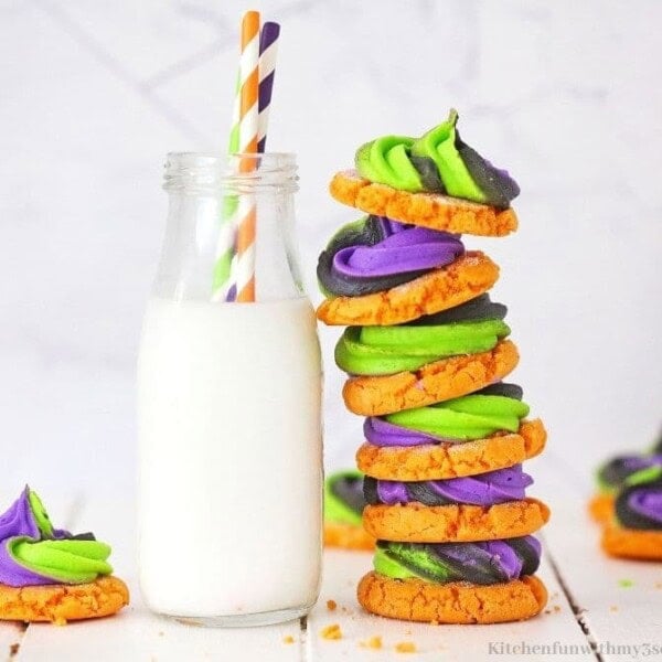 the cookies stacked by a glass of milk.