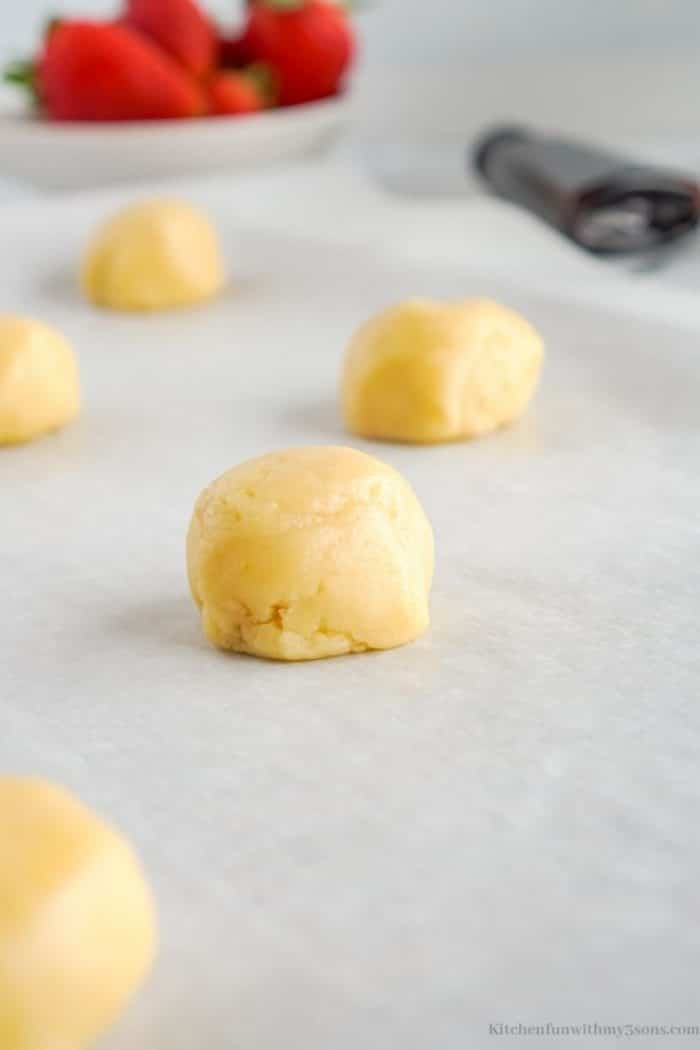Making cookie dough balls and placing onto the sheet pan.