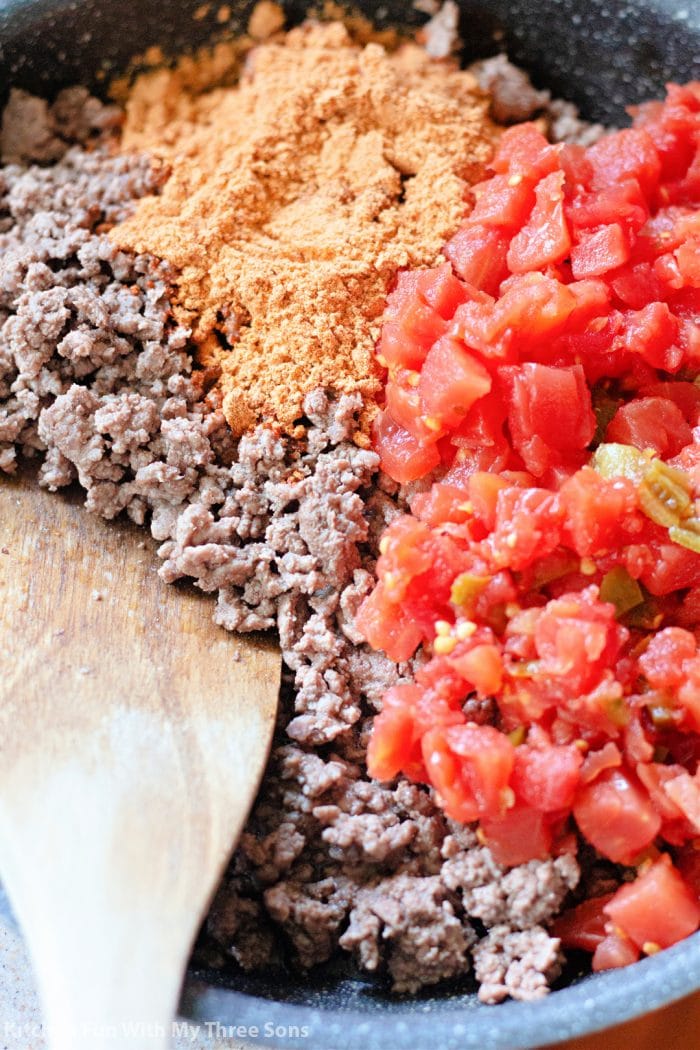 Cooking ground beef, tomatoes and seasoning mix in a skillet