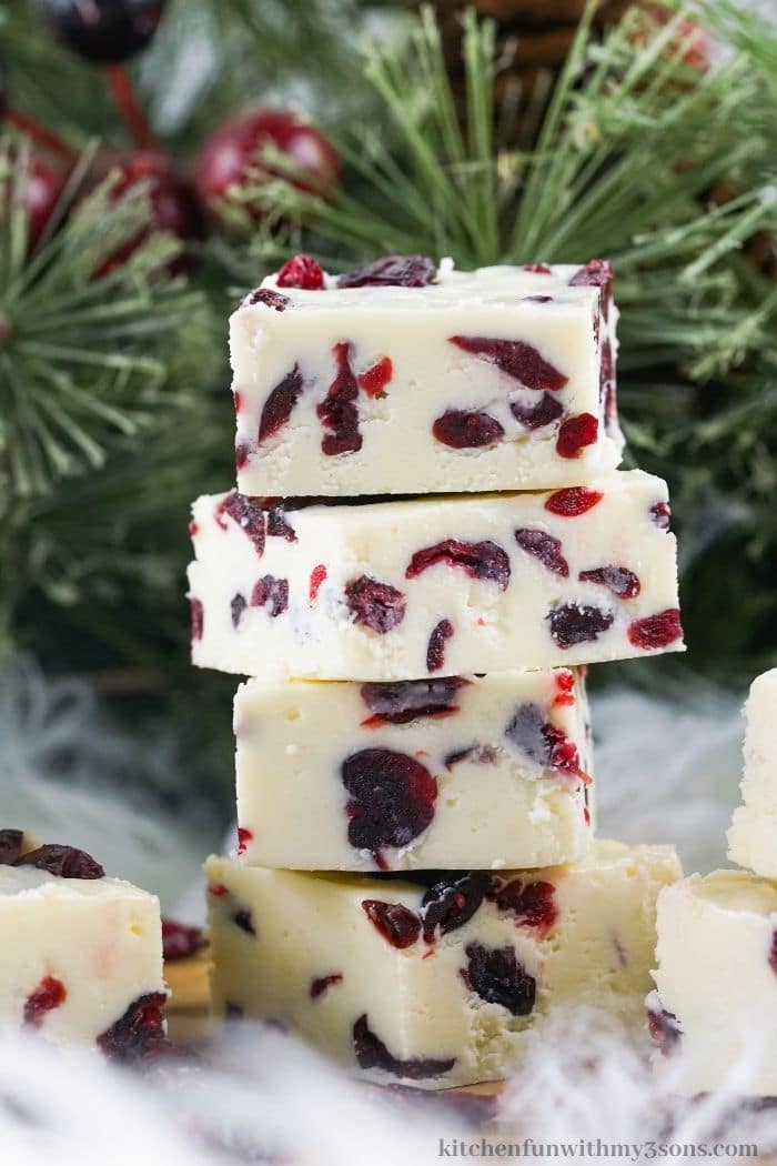 white chocolate cranberry fudge squares stacked on top of each other.