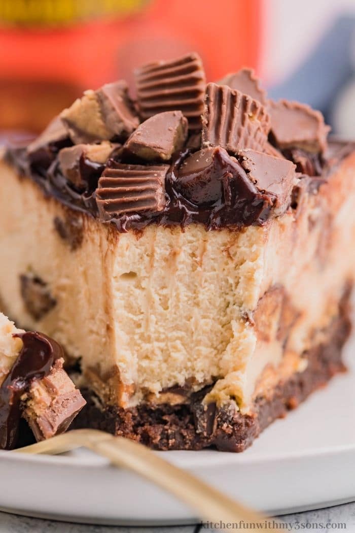 A piece of Reese's peanut butter cheesecake with a bite take out.