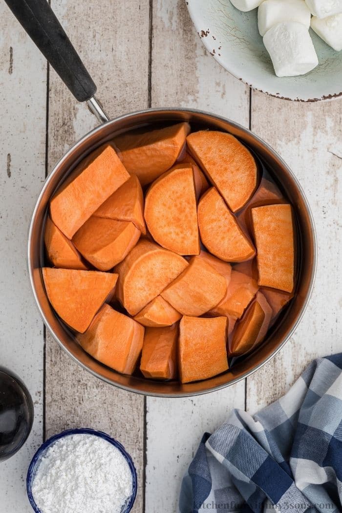Peeled and cubed sweet potatoes in a pot with water, ready to be boiled.