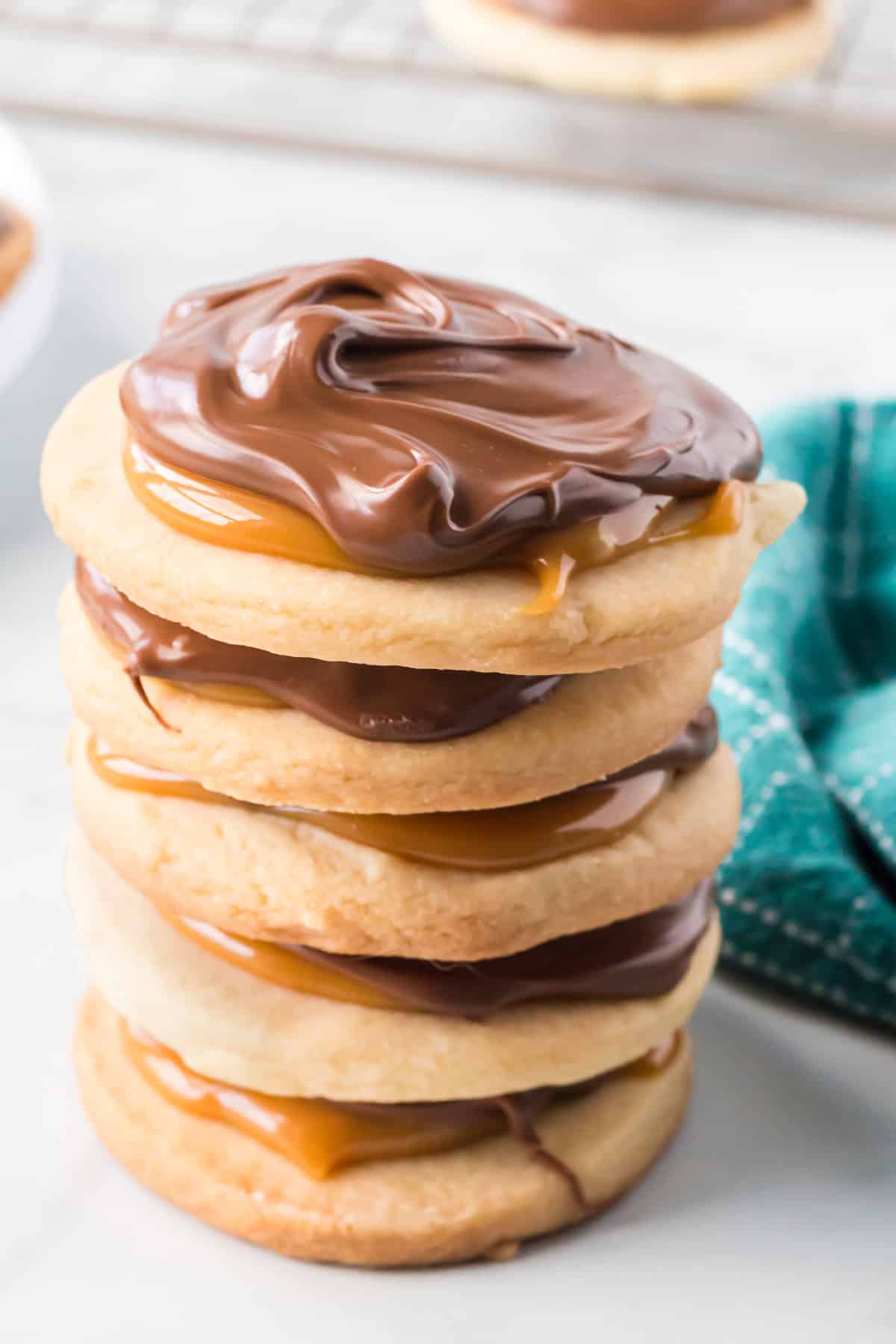 With a melt-in-your-mouth shortbread cookie base topped with caramel and milk chocolate, these Twix Cookies taste just like the candy bar. A stack of Twix cookies