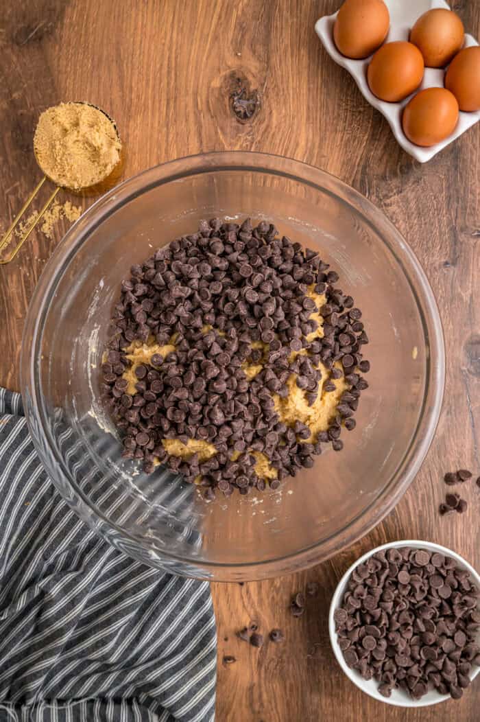 Chocolate chips added to a bowl of dough