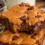 Two chocolate chip cookie bars stacked on each other, one with a bite missing