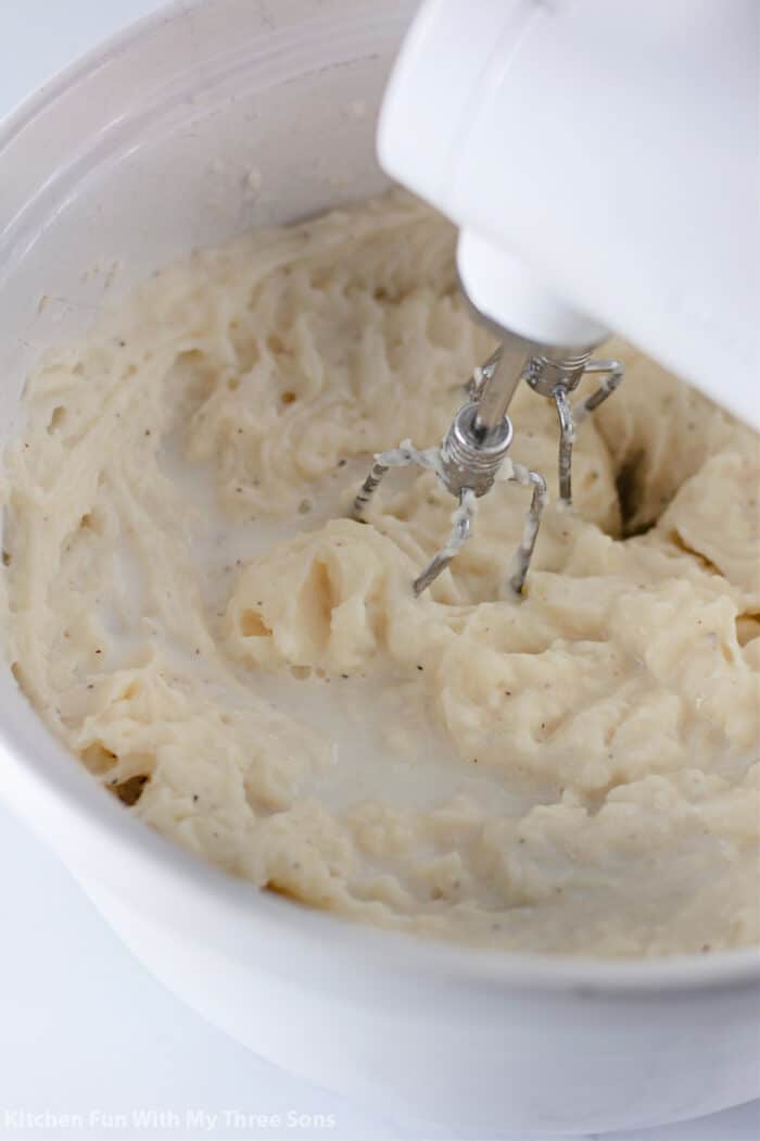 An electric mixer whipping mashed potatoes