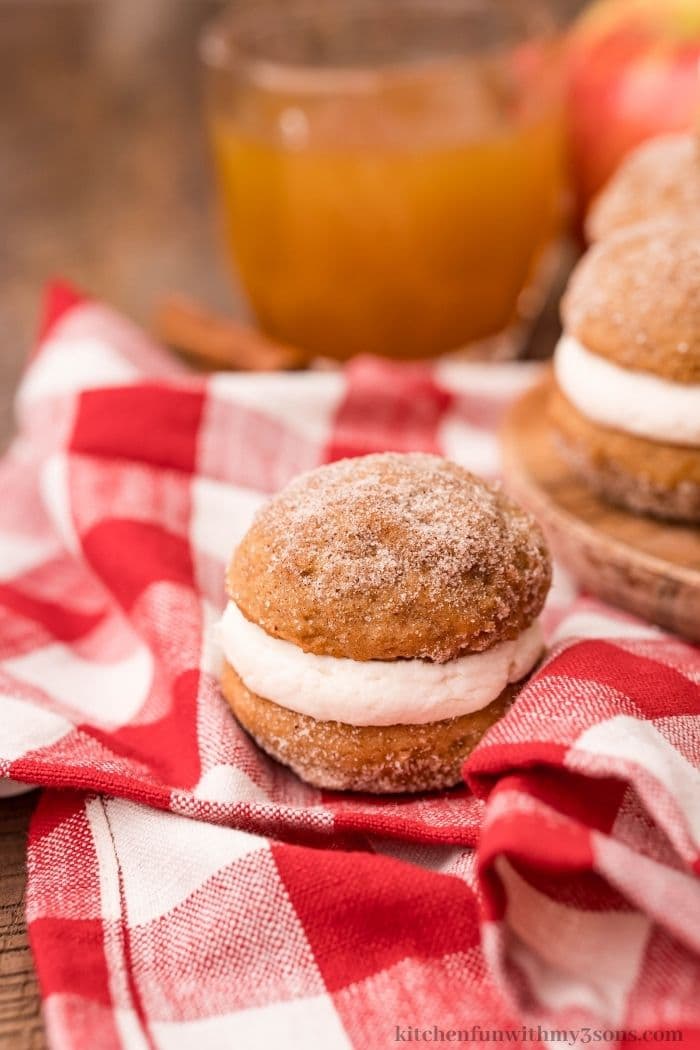A couple whoopie pies on a checkered cloth.