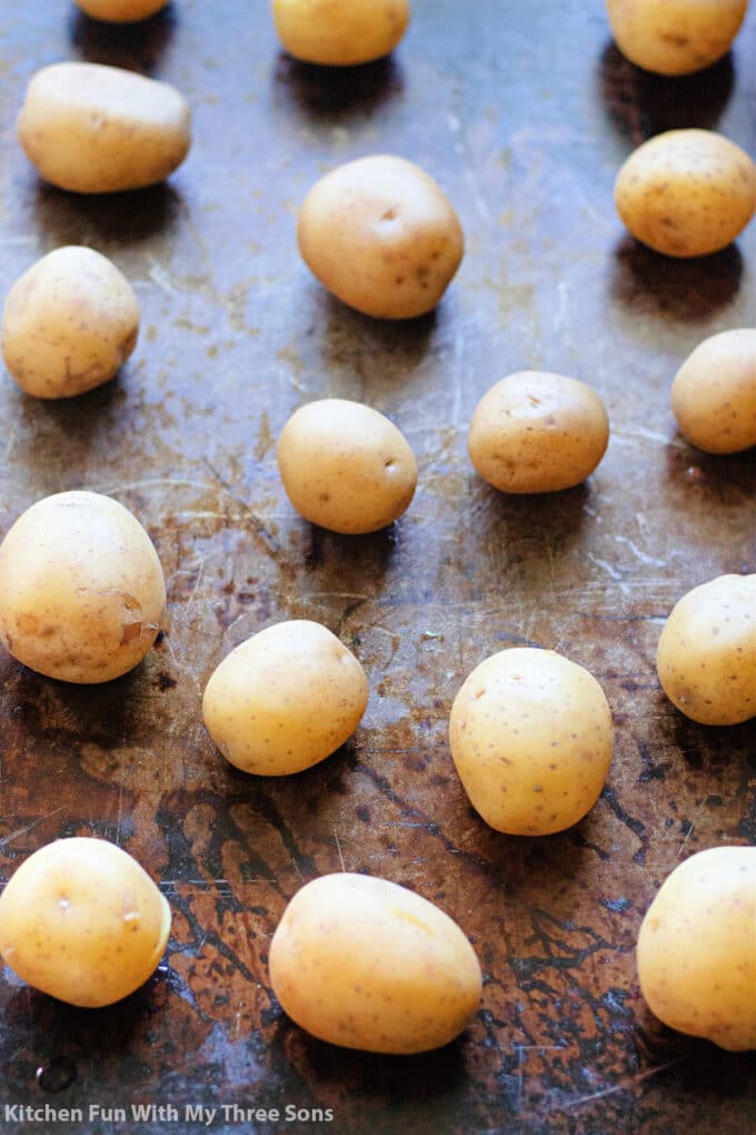 freshly boiled golden potatoes on a sheet pan.