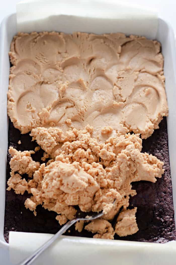 Spreading peanut butter filling over brownies