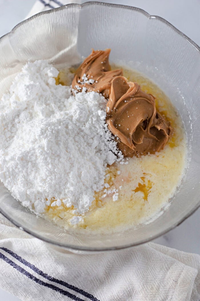 Melted butter, powdered sugar, and peanut butter in a bowl