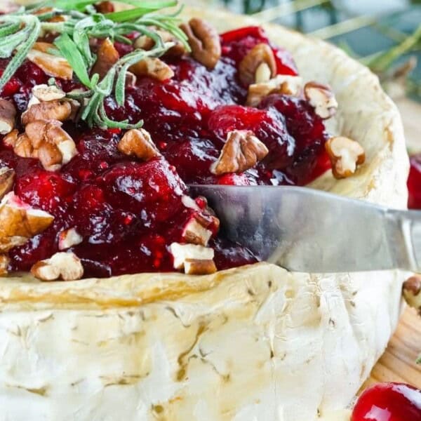 Cutting the brie with a cheese knife.