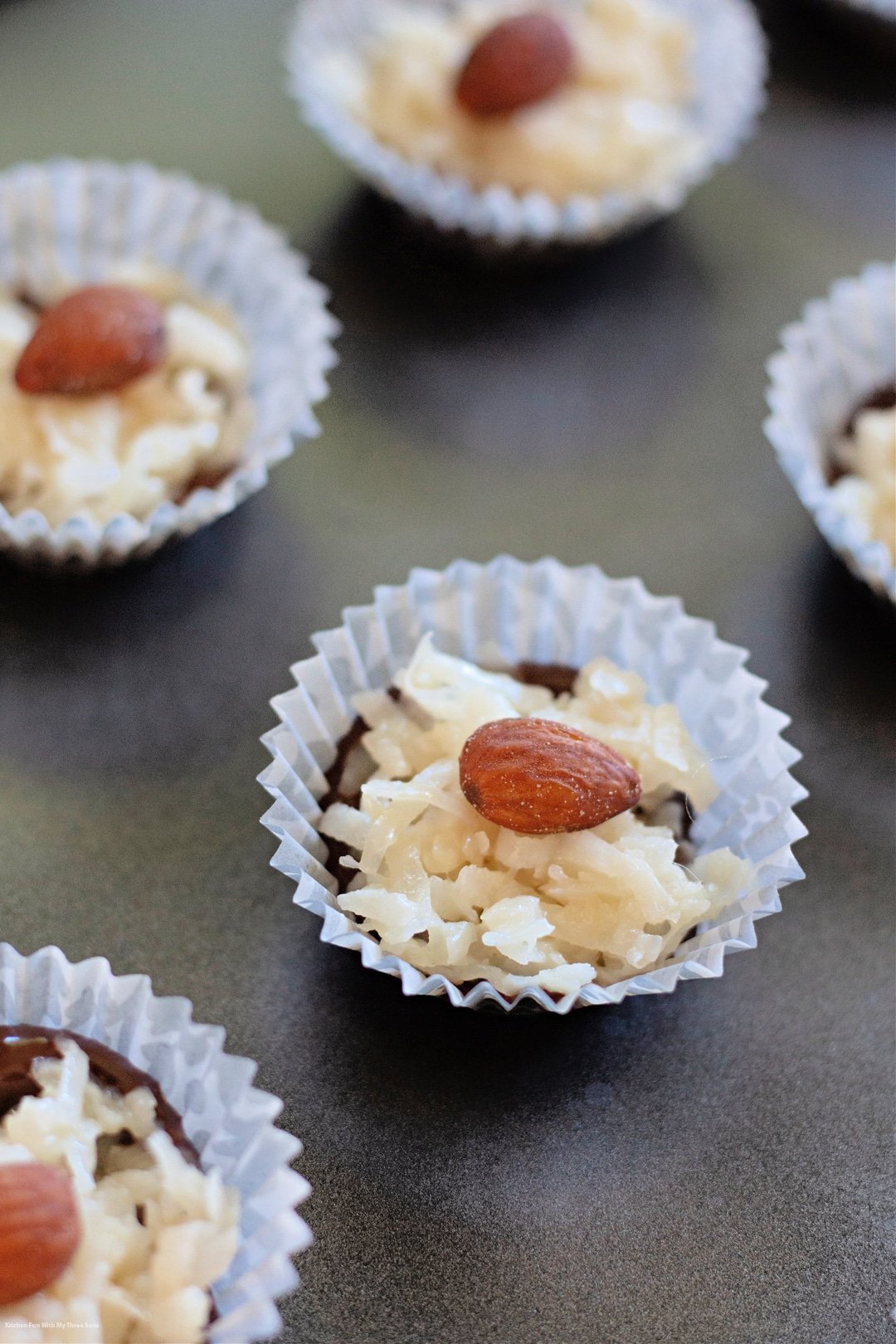 adding almond to the top of the coconut candies.
