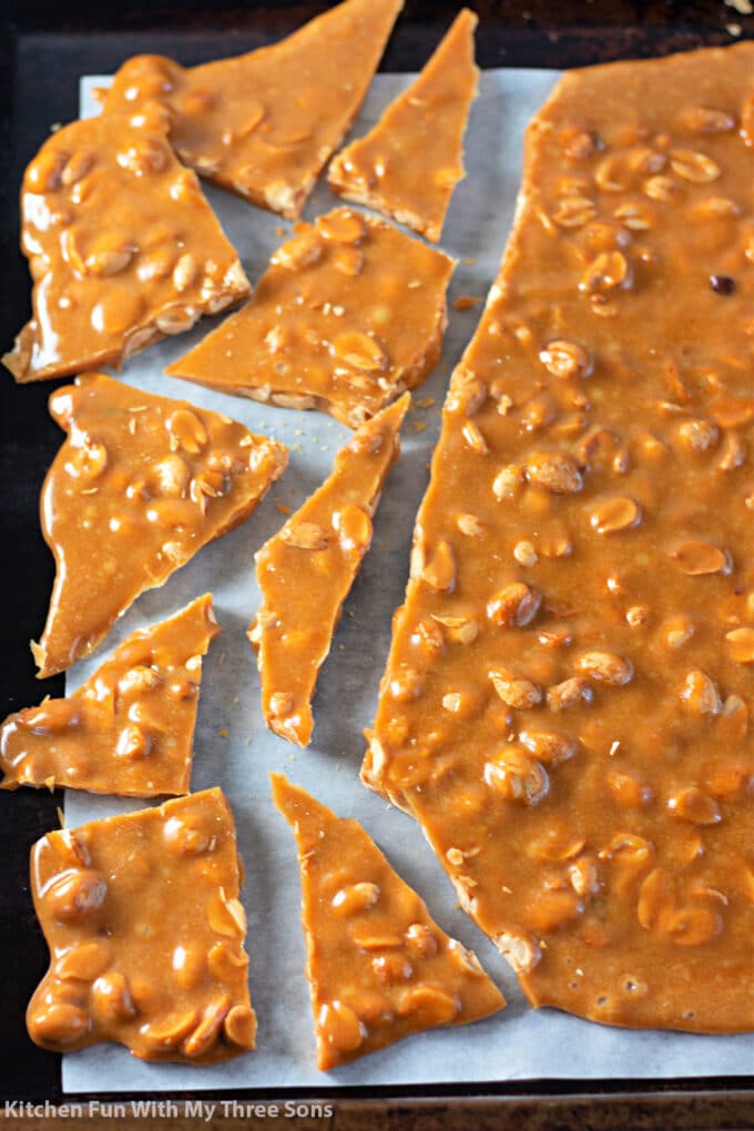 breaking up the freshly made Homemade Peanut Brittle Recipe.