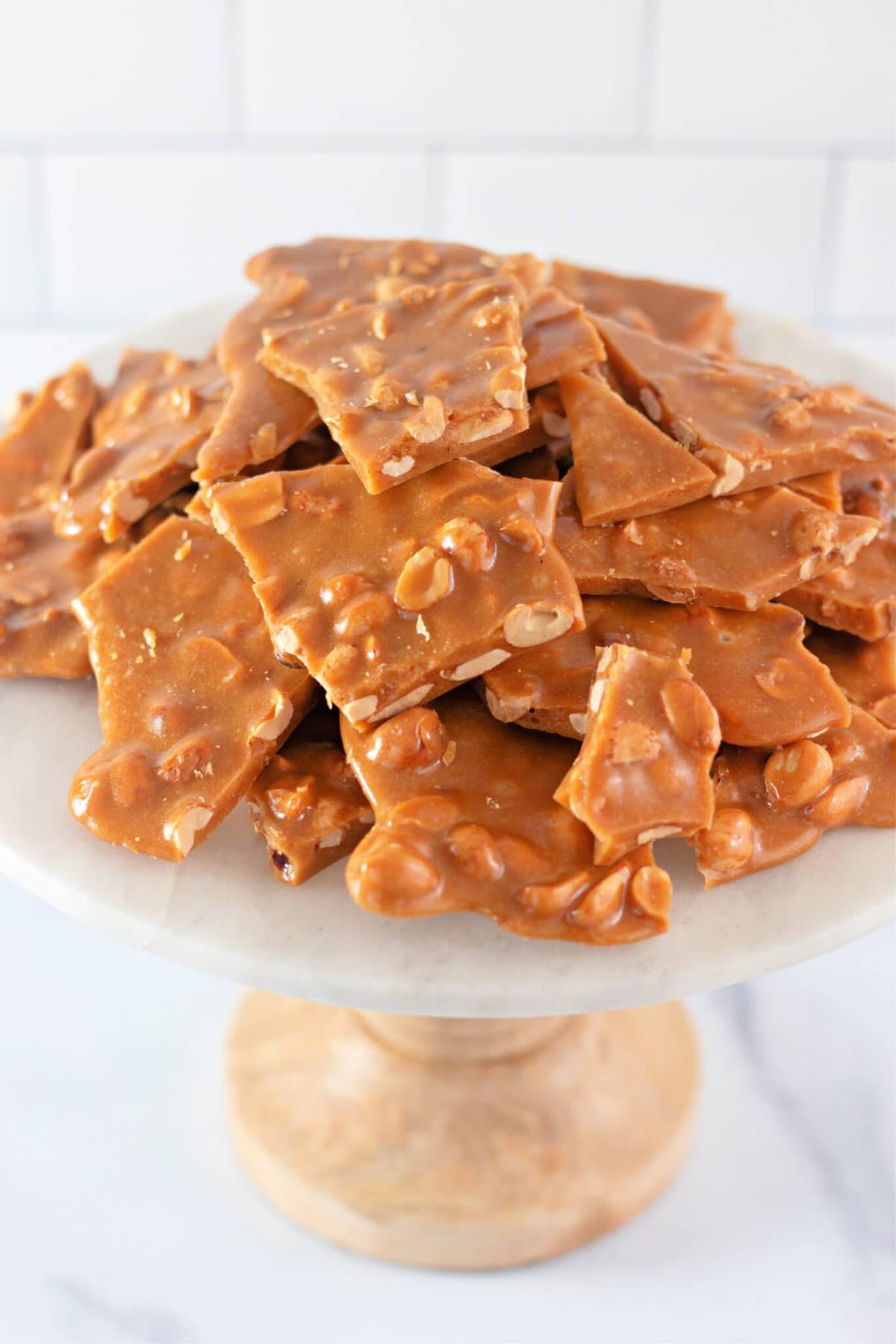 Homemade Peanut Brittle Recipe on a marble cake stand