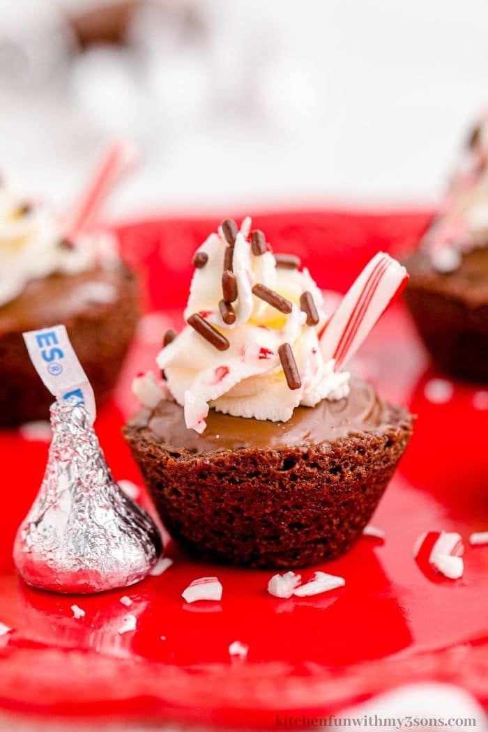 A chocolate kiss next to a brownie cup.