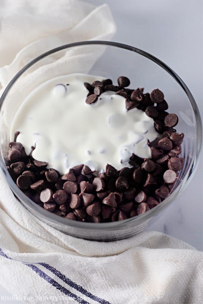 chocolate chips and cream in a clear bowl.