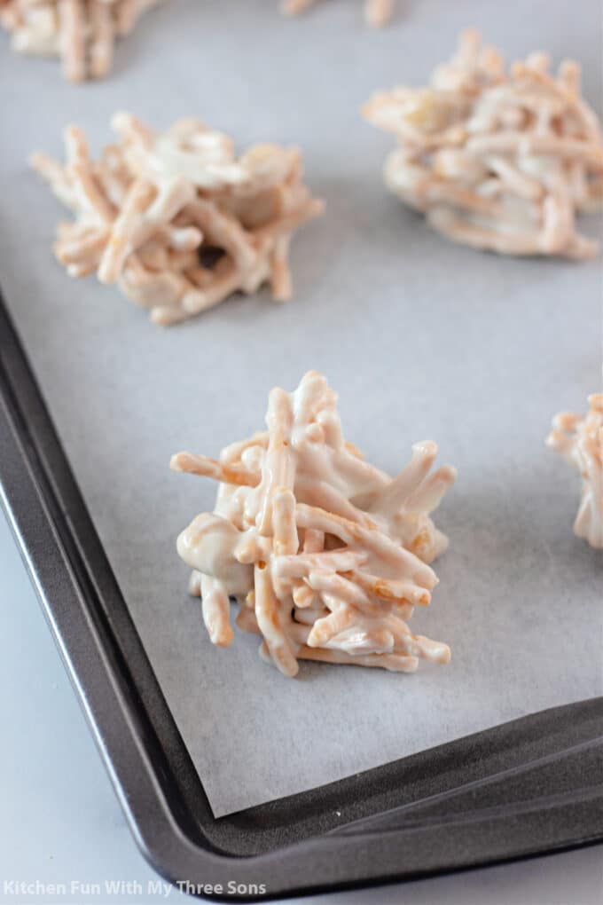 white chocolate and chow mein noodle mixture on a tray lined with parchment paper.