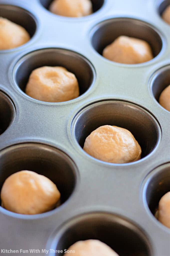 cookie dough balls in a mini muffin pan.