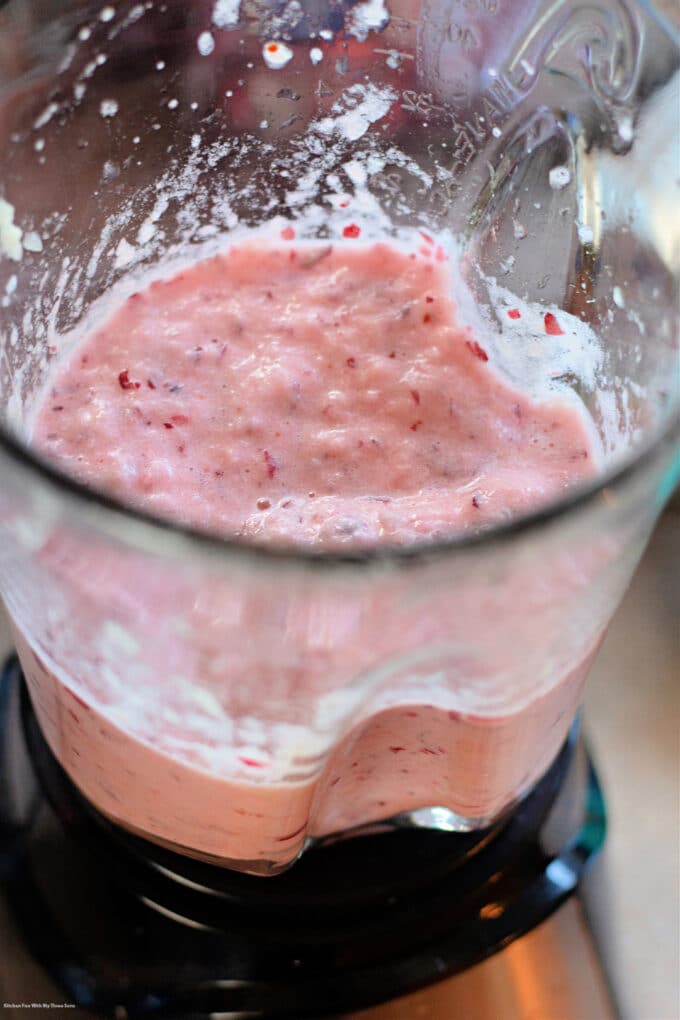 blending cranberries and pineapple in a blender.