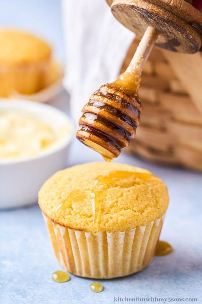 Adding honey on top of the muffins.