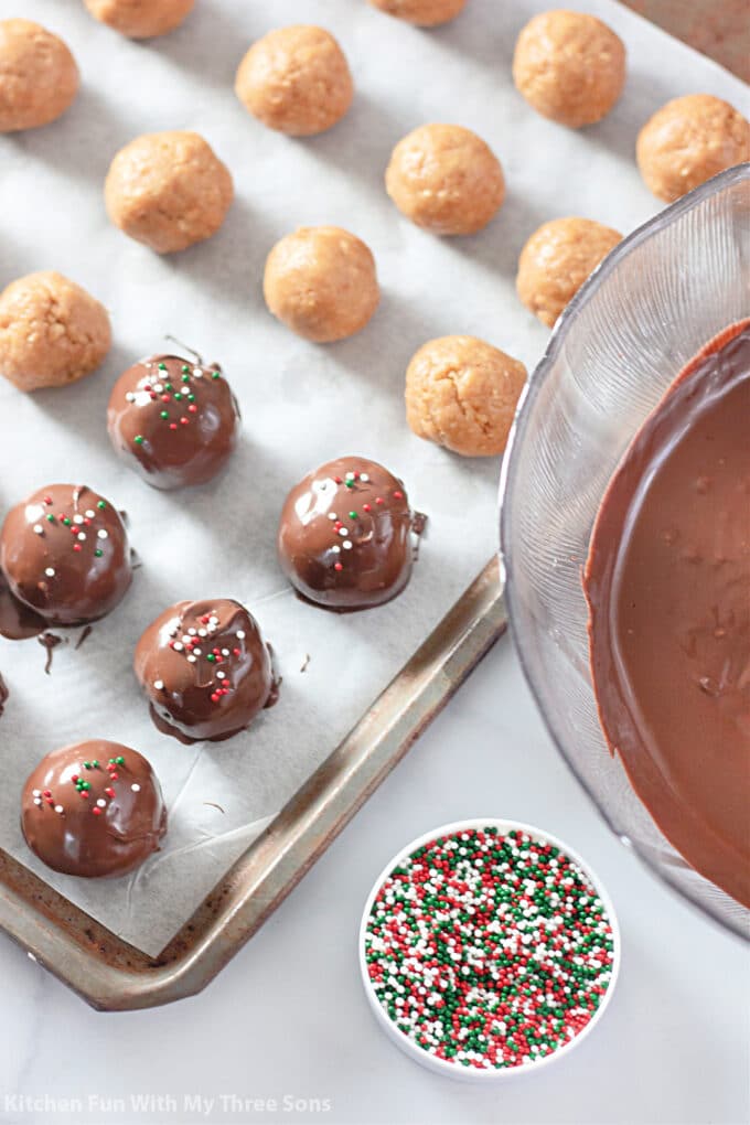 dipping the truffles in melted chocolate and topping with sprinkles.